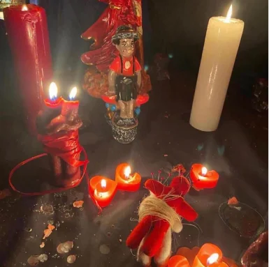 Figuras unidas con hilo rojo entre velas en forma de corazón